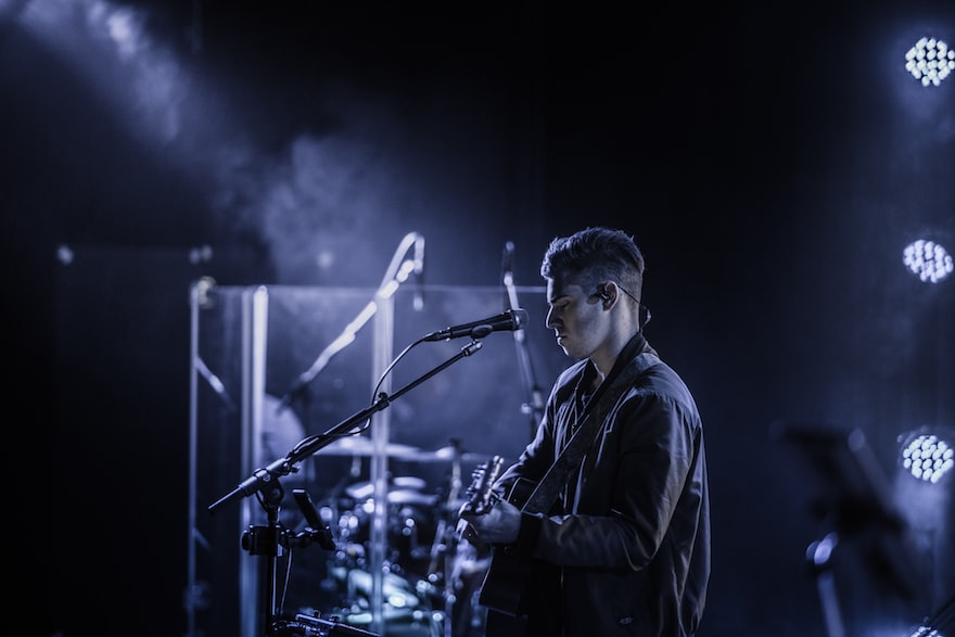 man playing guitar on stage